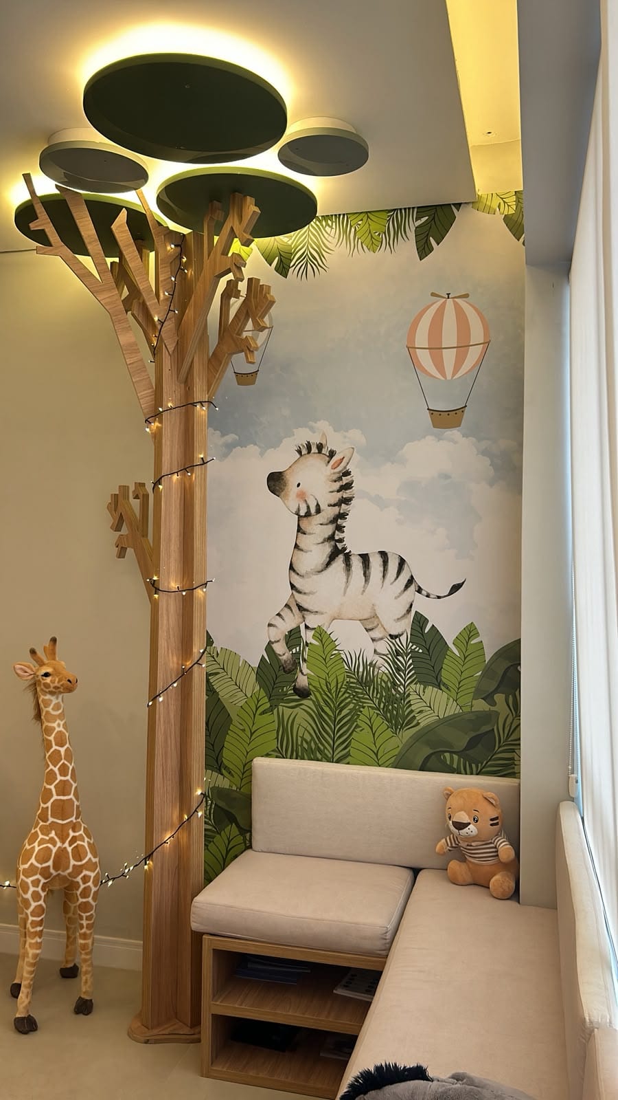 Sala de espera com árvore de madeira, mural de zebra e sofá